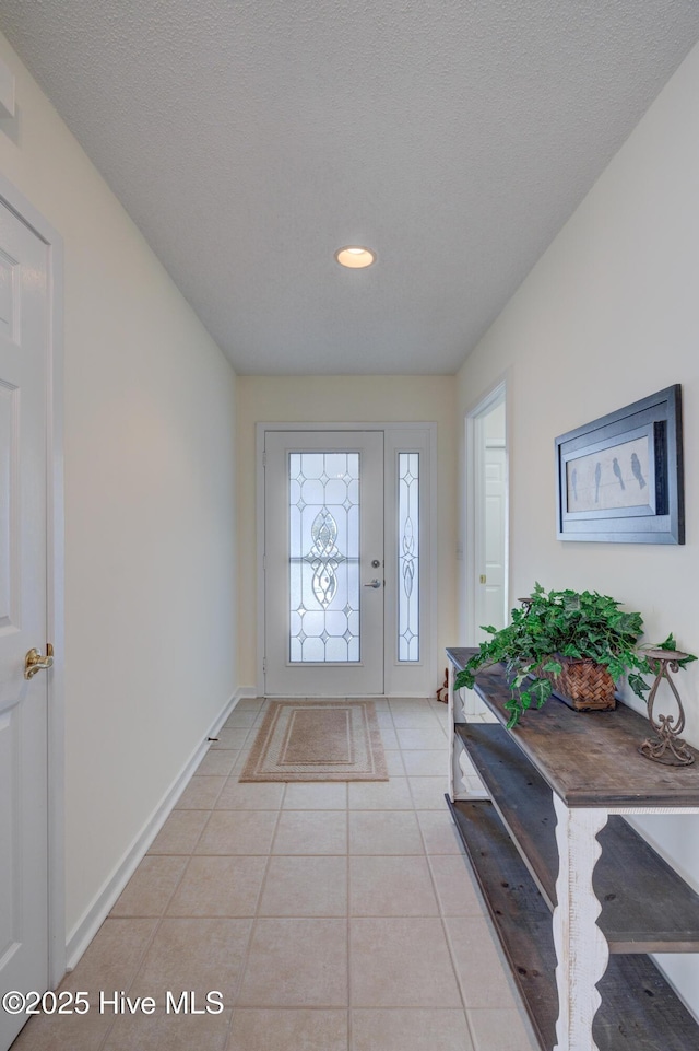 foyer entrance featuring light tile patterned floors and a textured ceiling