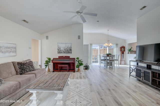 living room featuring high vaulted ceiling, ceiling fan with notable chandelier, and light wood-type flooring