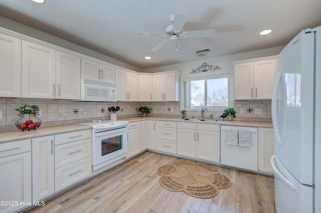 kitchen featuring sink, white cabinets, white appliances, and light hardwood / wood-style flooring