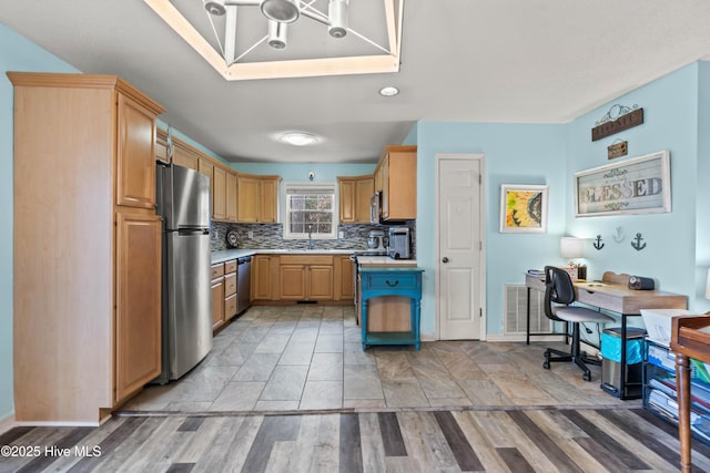 kitchen with light brown cabinetry, sink, light hardwood / wood-style flooring, appliances with stainless steel finishes, and decorative backsplash