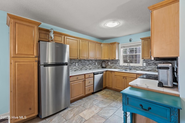 kitchen with appliances with stainless steel finishes, sink, decorative backsplash, and a textured ceiling