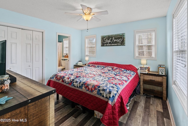 bedroom featuring ceiling fan, dark wood-type flooring, a textured ceiling, ensuite bath, and a closet