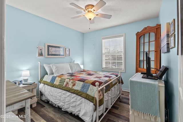 bedroom featuring ceiling fan, dark wood-type flooring, and a textured ceiling