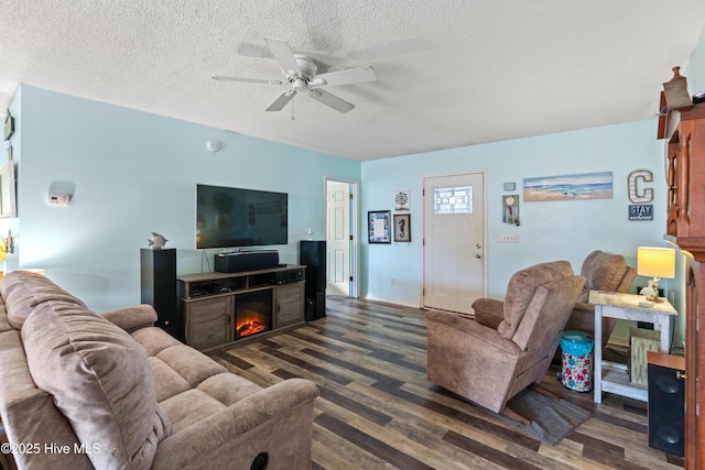 living room with ceiling fan, dark hardwood / wood-style floors, and a textured ceiling