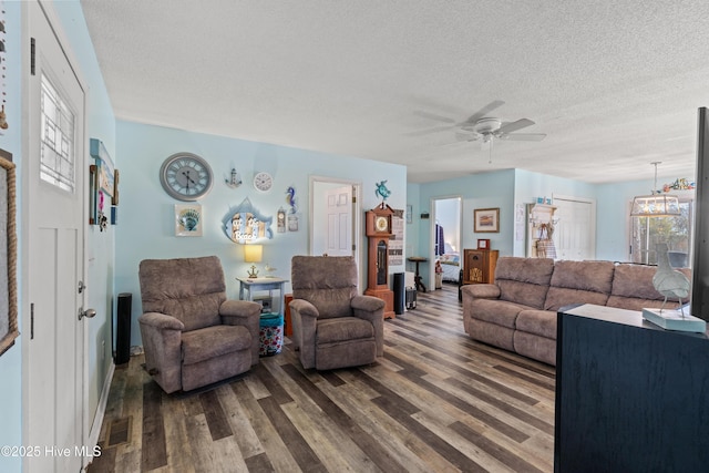 living room with ceiling fan, hardwood / wood-style flooring, and a textured ceiling