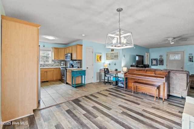 kitchen with stainless steel appliances, light brown cabinetry, light hardwood / wood-style floors, and decorative backsplash