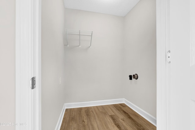 laundry area featuring hardwood / wood-style flooring and a textured ceiling