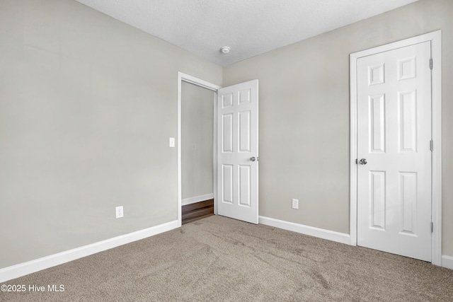 unfurnished bedroom featuring light colored carpet and a textured ceiling