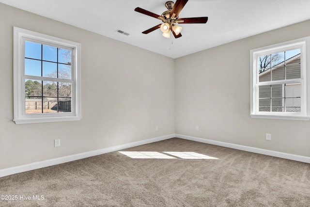 spare room featuring ceiling fan, a healthy amount of sunlight, and carpet