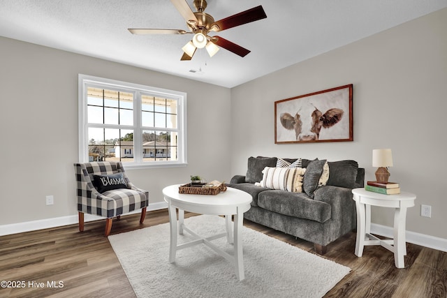 living room with dark hardwood / wood-style flooring and ceiling fan