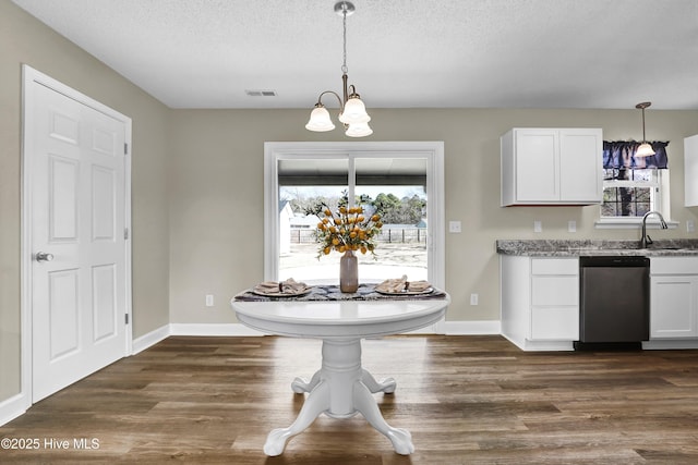 interior space featuring decorative light fixtures, sink, white cabinets, dark hardwood / wood-style flooring, and stainless steel dishwasher