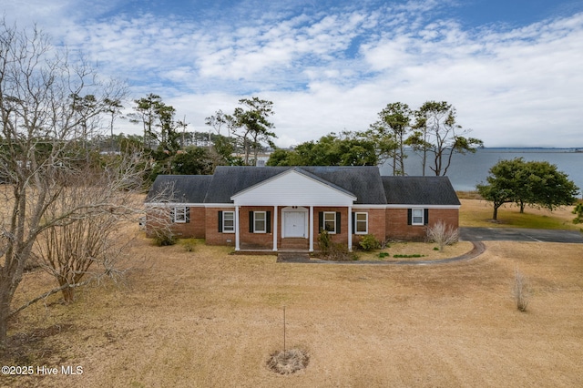 single story home featuring covered porch and a water view