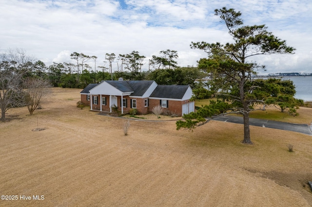 ranch-style home with a garage and a water view