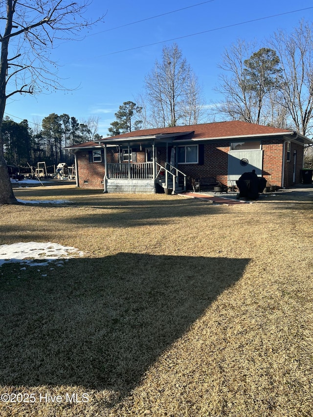 back of property featuring a yard and covered porch