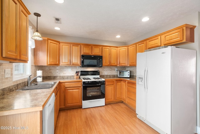 kitchen with sink, tasteful backsplash, pendant lighting, white appliances, and light hardwood / wood-style floors