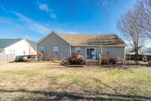 rear view of property with a deck and a lawn