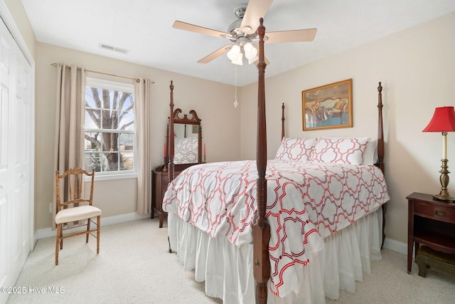 bedroom featuring light colored carpet, ceiling fan, and a closet