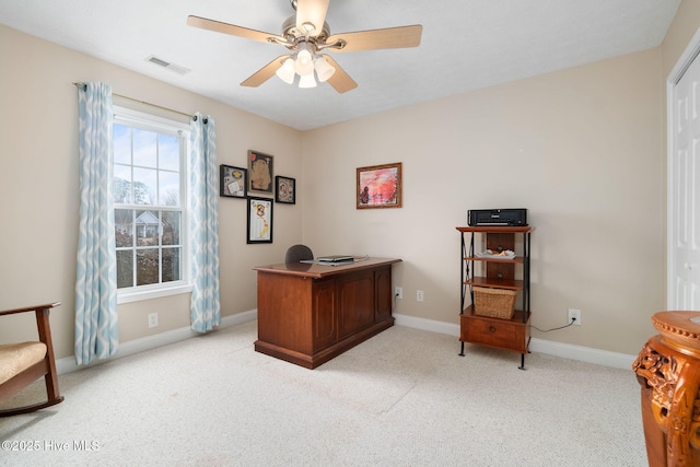 carpeted home office featuring ceiling fan