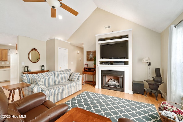 living room featuring lofted ceiling, ceiling fan, and light hardwood / wood-style flooring