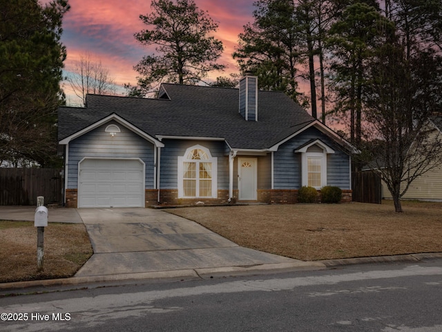 view of front of home with a garage and a lawn