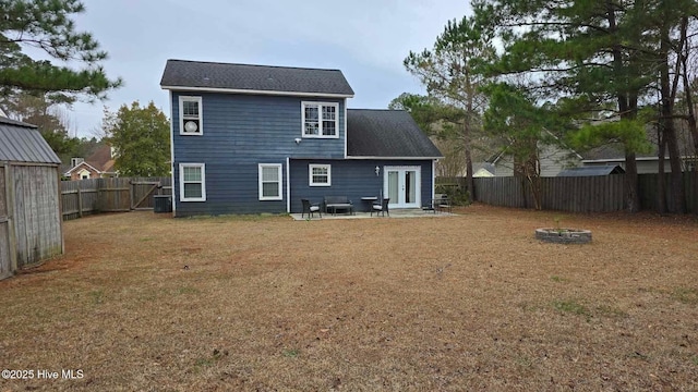 rear view of house with a yard, a patio area, central AC, and an outdoor fire pit