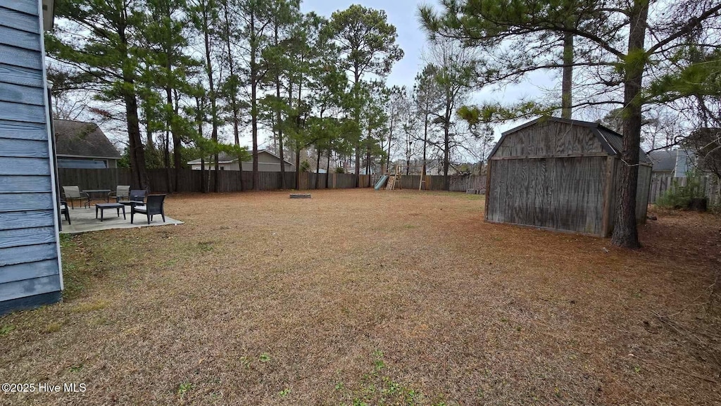 view of yard with a storage unit and a patio area