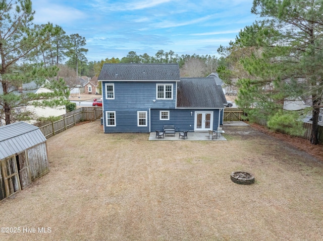 back of house featuring a patio, a lawn, and an outdoor fire pit