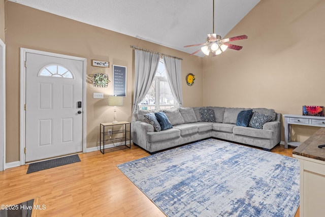 living room featuring wood-type flooring, lofted ceiling, and ceiling fan