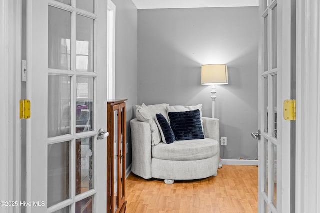 living area with hardwood / wood-style flooring and french doors