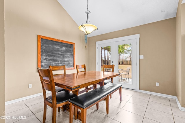 dining area featuring french doors, light tile patterned flooring, and vaulted ceiling