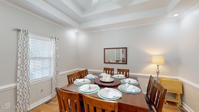 dining room with light hardwood / wood-style floors and a tray ceiling