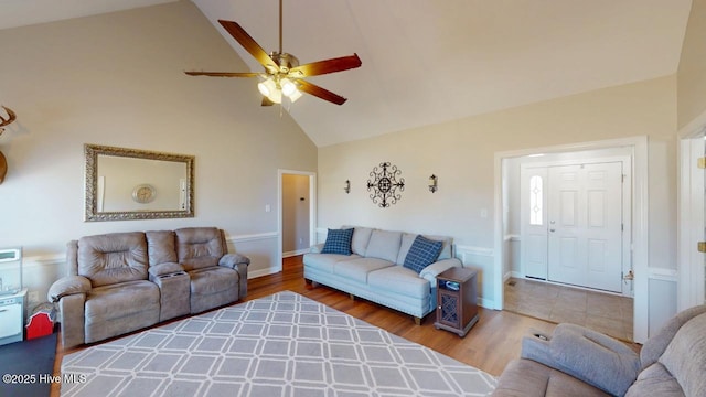 living room featuring hardwood / wood-style flooring, high vaulted ceiling, and ceiling fan