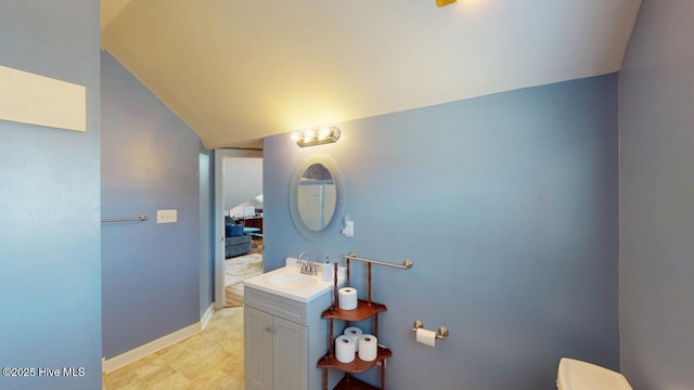 bathroom featuring lofted ceiling and vanity