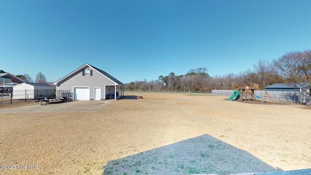 view of yard with a playground, a garage, and an outbuilding