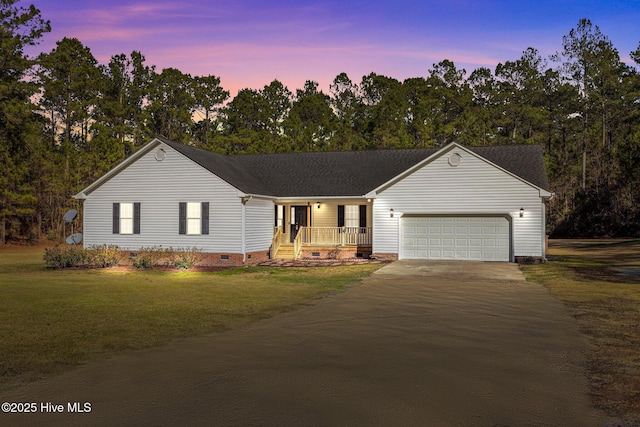 ranch-style house with a garage, a porch, and a yard