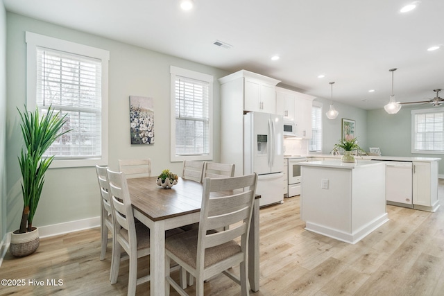 dining area with light hardwood / wood-style flooring and a healthy amount of sunlight