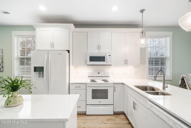 kitchen with sink, white appliances, decorative light fixtures, and white cabinets