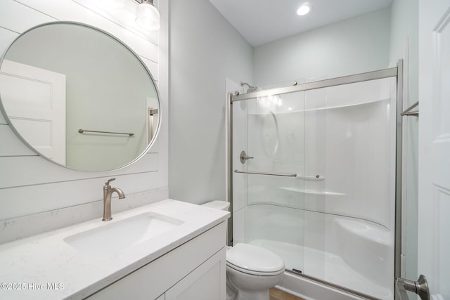 bathroom with vanity, a shower with shower door, and toilet