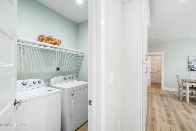 laundry room featuring light hardwood / wood-style flooring and washer and clothes dryer