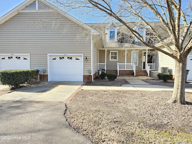 view of front of house with cooling unit, a porch, and a garage