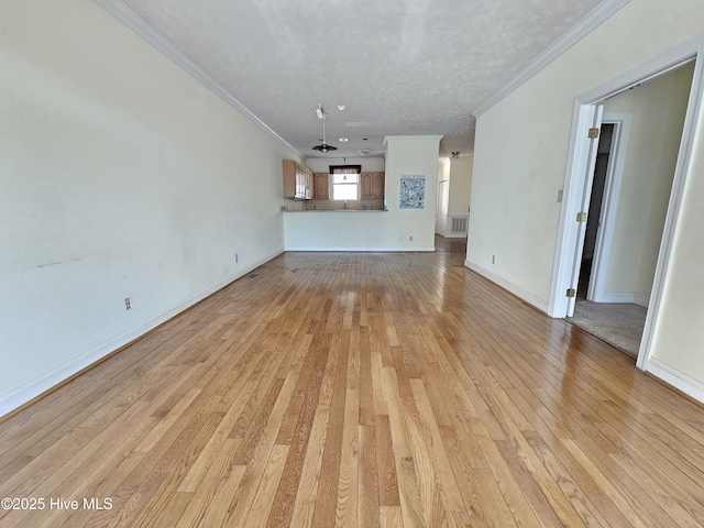 unfurnished living room featuring ornamental molding, light hardwood / wood-style floors, and a textured ceiling