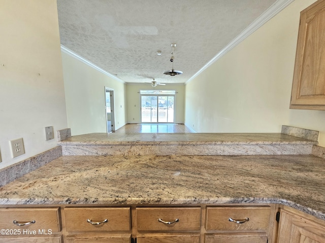 kitchen featuring crown molding, kitchen peninsula, and a textured ceiling