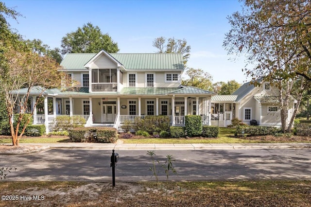 farmhouse featuring covered porch and a sunroom