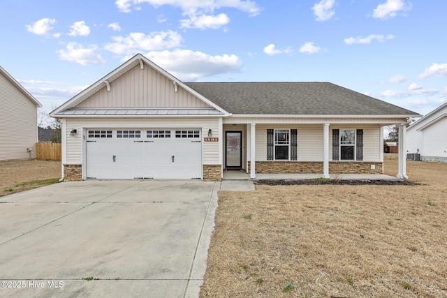 view of front of property with a garage, a front lawn, and covered porch