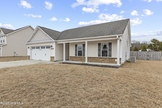 view of front of property with central AC unit, a garage, a front yard, and covered porch