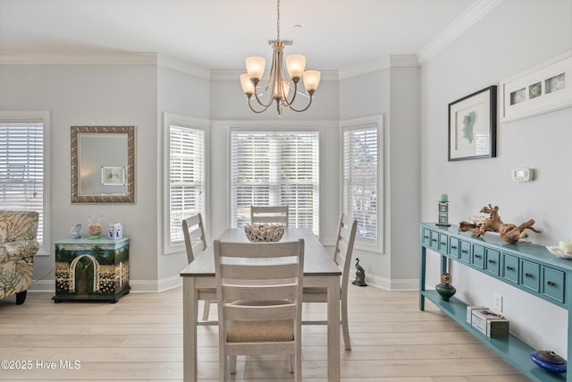 dining space with crown molding, a notable chandelier, plenty of natural light, and light wood-type flooring