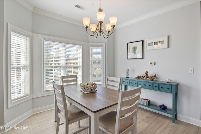 dining space featuring crown molding, a chandelier, and light hardwood / wood-style flooring