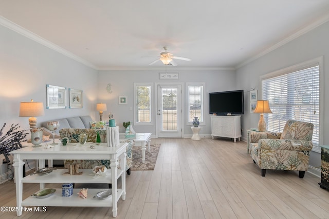 living room featuring ceiling fan, crown molding, a healthy amount of sunlight, and light wood-type flooring