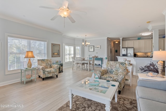 living room with ceiling fan with notable chandelier, light hardwood / wood-style flooring, and ornamental molding