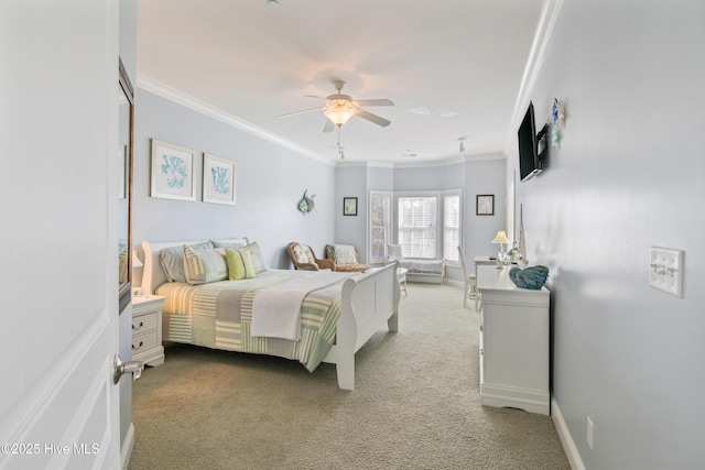 carpeted bedroom featuring crown molding and ceiling fan